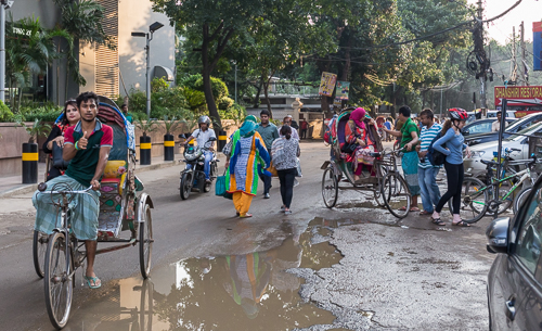 Colourful street scene outside the hotel. On the right a very rare side: a foreigner getting ready to cycle!