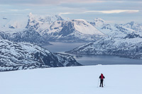Paul on his way to the edge of the plateau, with Kvaløya in the background