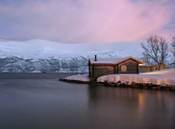 A cabin at dusk. The long exposure (13 sec) makes the water smooth, and you can also see movement in the tree :)