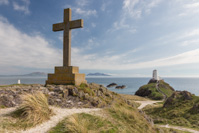 The cross on top of the island, with Twr Bach on the left and the lighthouse Twr Mawr on the right