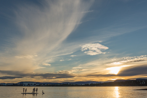 Sunset while a group of kids plays in the water