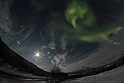 Swirling aurora and a full moon